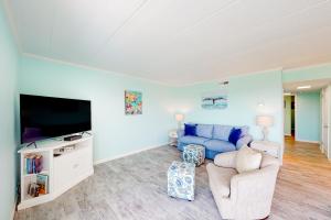大洋城Assateague House 306的客厅配有蓝色的沙发和电视