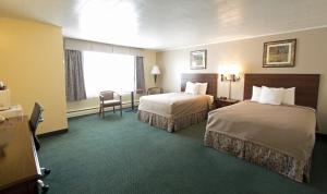 布伦瑞克旅行者酒店的酒店客房设有两张床和窗户。