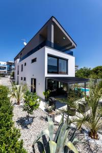 克尔克Luxury Villa Adria Apartments的黑色屋顶的白色房子