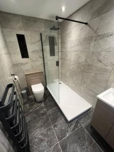 卡迪夫Stylish Penarth Marina Apartment的带淋浴、卫生间和盥洗盆的浴室