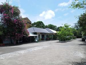 多森Nha Khach Hai Quan的鲜花盛开的房子前的一条空的街道