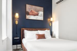 费城Sosuite at French Quarters - Rittenhouse Square的卧室配有白色的床和蓝色的墙壁