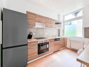 杜伊斯堡RAJ Living - 3 and 4 Room Apartments的一个带木制橱柜和大窗户的厨房