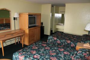 盖恩斯维尔盖恩斯维尔旅行者酒店的酒店客房设有两张床、一张桌子和一台电视。