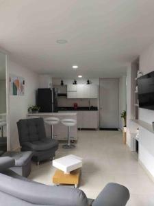 萨瓦内塔Apartamento nuevo, próximo al metro y CC Mayorca的带沙发和椅子的客厅以及厨房。