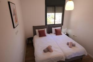 耶路撒冷Beautiful 2BR near Mahane Yehuda的卧室配有一张带两个枕头的大白色床