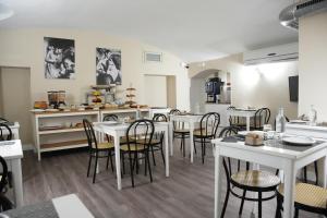 都灵Hotel Montevecchio的一间设有白色桌椅的用餐室
