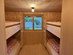 布劳瓦尔德Sunnehuesli的小木屋设有两张双层床和一扇窗户