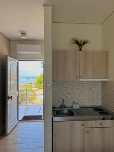 KaravómilosBay Holiday Hotel & Spa的一个带水槽的厨房,享有海景