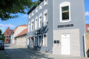 施韦特Pension Hilges im Herzen der Altstadt的街上有白色门的灰色建筑