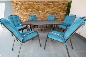 奥拉迪亚Backyard Jacuzzi House的一组椅子和一张带蓝色椅子的桌子