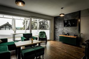 兹维日涅茨Domy na Roztoczu Aleja Lipowa A H的客厅配有桌子和绿色椅子