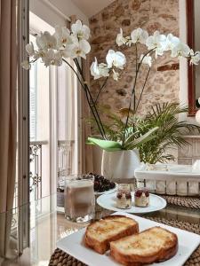 昂蒂布L appartement de Manon, centre historique du vieil Antibes的一张桌子,上面放着两盘面包和白色的花