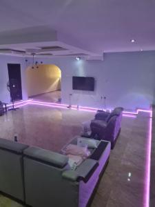 伊巴丹Chic 4 Bed bungalow Oluyole Akala express Ibadan的客厅配有紫色沙发和电视
