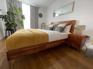 伦敦Peloton Organic Health Apartment in Angel, Old Street, Islington的一间卧室配有一张带黄色毯子的大床
