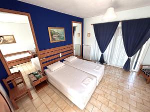 KaravómilosBay Holiday Hotel & Spa的一间卧室设有一张床和蓝色的墙壁