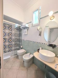 卡普里Hotel Guarracino的一间带水槽、卫生间和镜子的浴室