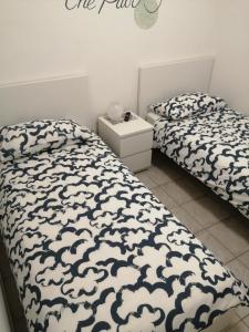 ManoppelloB&B COLLE TARIGNI的一间卧室配有两张床和白色及黑色的棉被