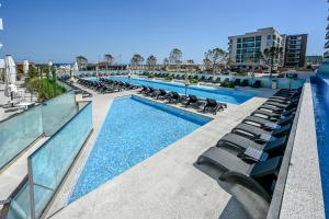 北马马亚-讷沃达里Crystal Beach - Infinity Pool & Spa Resort的大楼内一个带躺椅的游泳池