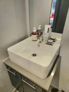 比勒陀利亚Circa Aparthotel - 1 Bedroom Apartment - close to Menlyn的浴室设有白色水槽和镜子