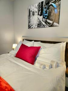 比勒陀利亚Circa Aparthotel - 1 Bedroom Apartment - close to Menlyn的一张带红色枕头的白色床和挂在墙上的自行车