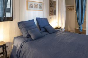 圣马丹德雷La Martinoise Studio的一间卧室配有蓝色的床和蓝色枕头