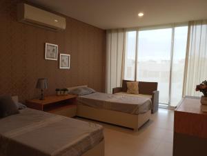 比亚埃尔莫萨Puerta Dorada country的一间卧室设有两张床、一张沙发和一个窗口