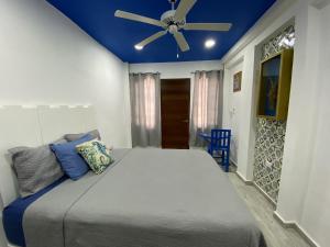 女人岛Casa María的一间卧室配有一张大床和吊扇