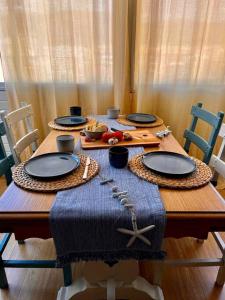 卡里拉Apartamento “La Caleta”的一张木桌,上面放有盘子和食物
