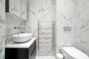 伦敦3 Bedroom flat with Terrace in Central London的白色的浴室设有水槽和卫生间。
