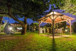 弗瓦迪斯瓦沃沃Willa Rodos II的公园里的一个凉亭,晚上有桌椅