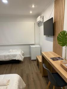 里奥夸尔托Apart IMEB spa & wellness的小房间设有一张床、一张桌子和一台电视机