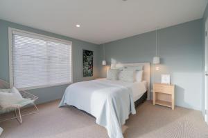 蒂阿瑙Southland Sounds - Te Anau Holiday Home的卧室配有白色的床和窗户。