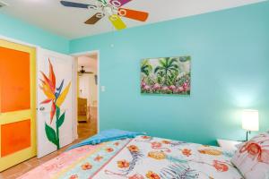 圣彼得堡Colorful Gulfport Home Walk to the Art District!的一间卧室配有一张床和吊扇