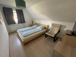 梅明根#7 Doppelzimmer mit Gemeinschaftsbad的卧室配有床、椅子和窗户。