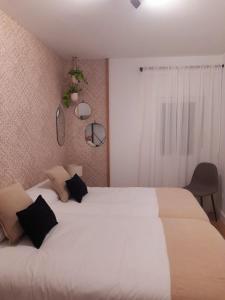 罗德里戈城VuT - El Balcón de la Plaza - A的一间卧室配有两张白色的床和黑色枕头