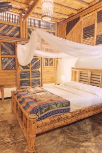 帕洛米诺Coco Sänkala Hostel的卧室配有一张床铺,位于带木墙的房间内