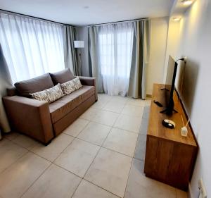 萨尔塔Casa en Salta的客厅配有棕色沙发和电视