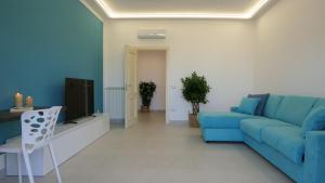 卡斯特拉玛雷帝斯达比亚Maison Lucia的客厅配有蓝色的沙发和电视