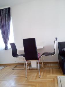 萨拉热窝Apartmani Aeredrom的客厅配有两把椅子和一张桌子