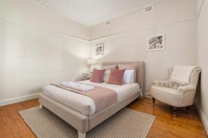 奥兰治Sampson Cottage - Historic Charm的白色卧室配有床和椅子