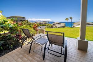 拉海纳毛伊岛卡普鲁亚别墅公寓式酒店的两把椅子位于一个享有海景的庭院内