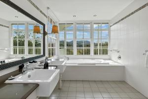 Gocup尼波山林小屋的白色的浴室设有2个盥洗盆和1个浴缸。
