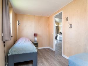 阿克伦Disabled house on the water, on a holiday park in Friesland的一间小卧室,配有一张床和一个走廊