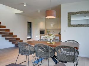 普拉Modern villa swimming pool , outdoor kitchen and fenced garden的一间带木桌和椅子的用餐室