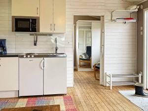 ArkelstorpHoliday home ARKELSTORP的厨房配有白色橱柜和水槽