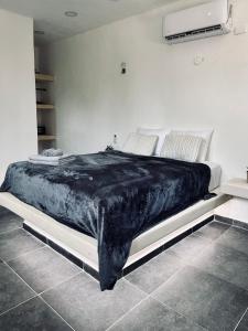 奥尔沃克斯岛Casa Tsunuum的卧室里的一张床铺,上面有黑色毯子