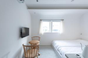金泽NODE SAIGAWA的一间卧室配有一张床、一张桌子和一个窗户。