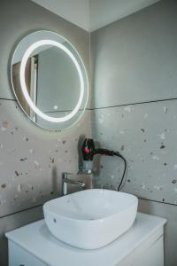 卡萨拉戈德Fortview Suites的浴室设有白色水槽和镜子
