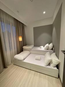 SengkuangMonde Residence H12 Batam Centre的带窗户的客房内设有两张单人床。